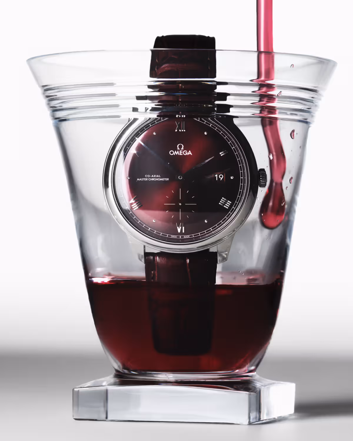 Glass by THOM BROWNE X BACCARAT and watch by OMEGA.