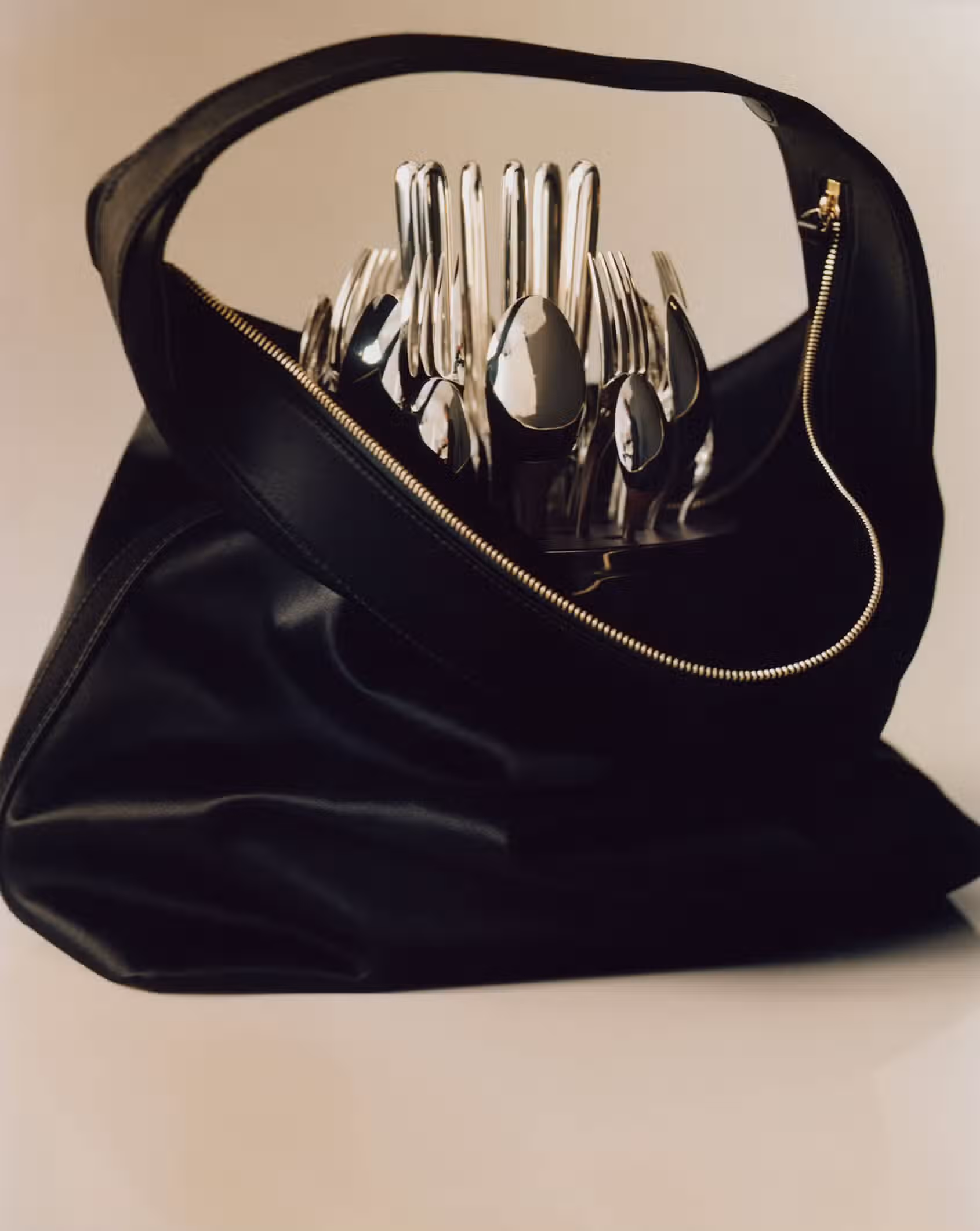 Bag by LOULOU STUDIO and cutlery by CHRISTOFLE.
