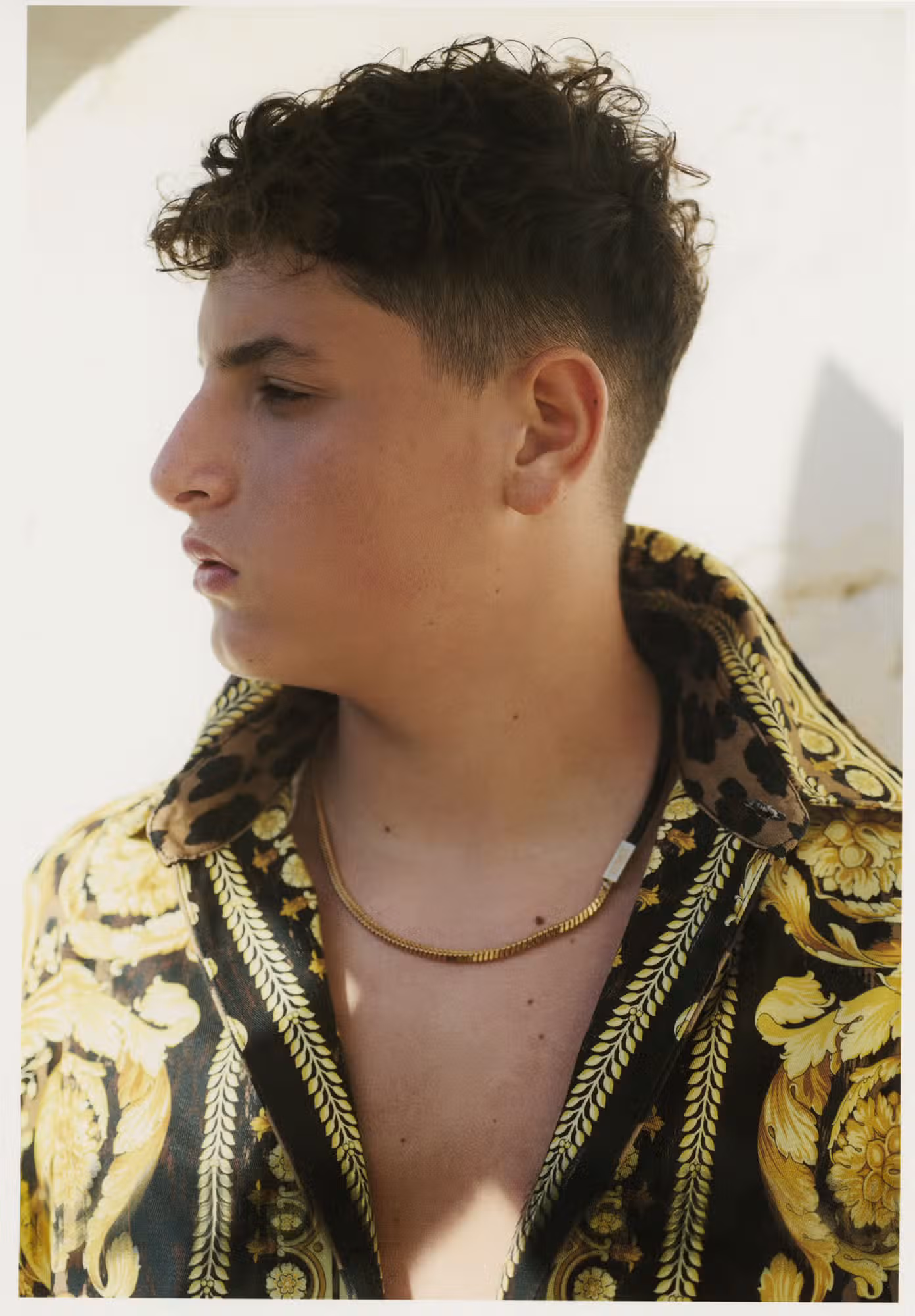 Diego wears shirt and necklace by VERSACE.
