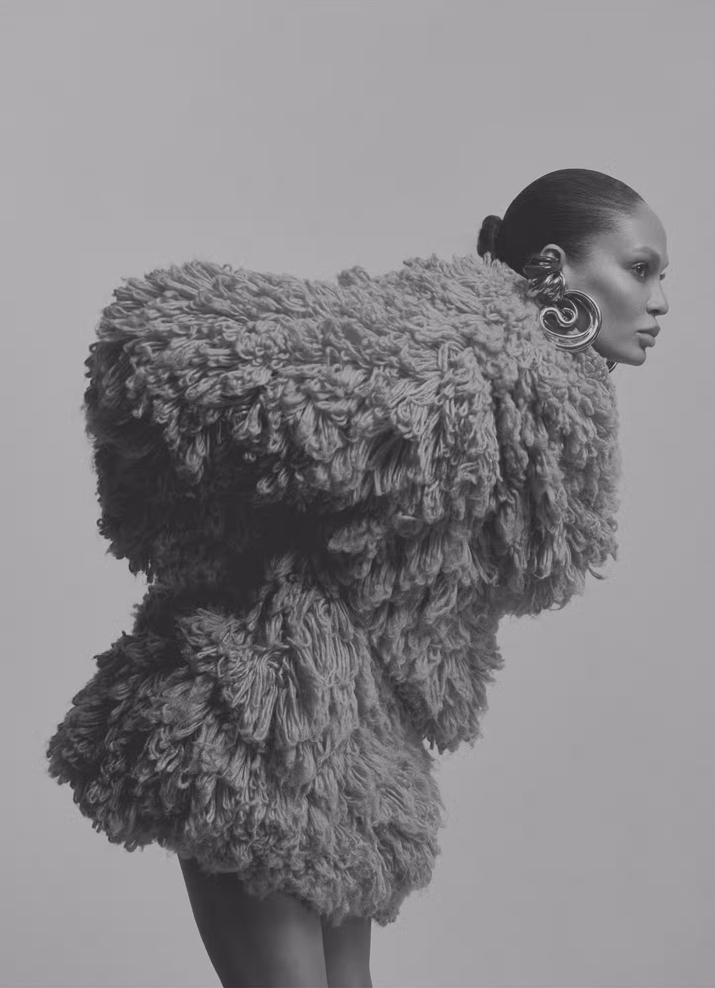 Joan wears coat by ALAÏA and earrings by PANCONESI.