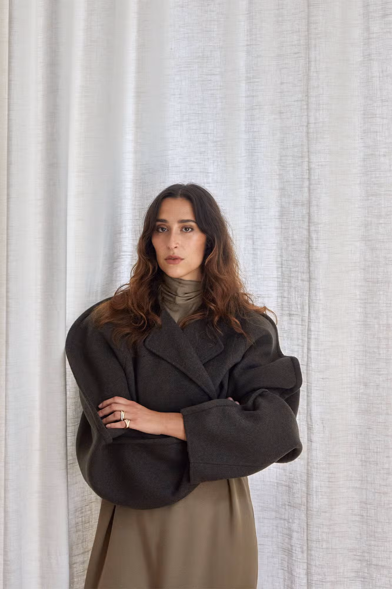 Chloe Wise wears full look by KHAITE and rings by CARTIER.